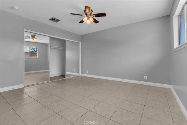 unfurnished bedroom with a ceiling fan, a closet, and baseboards