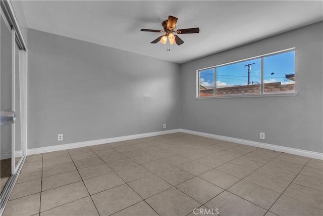 empty room with ceiling fan and baseboards