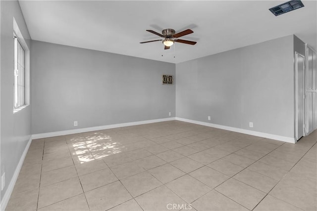 spare room with ceiling fan, visible vents, and baseboards