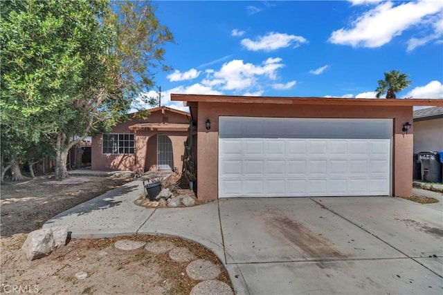 ranch-style house with a garage, concrete driveway, and stucco siding