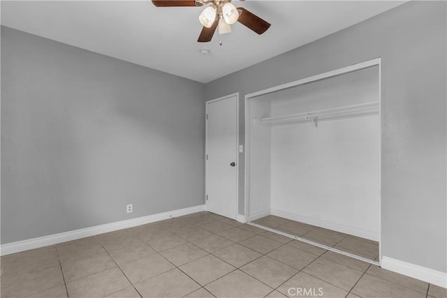 unfurnished bedroom featuring ceiling fan, a closet, tile patterned floors, and baseboards