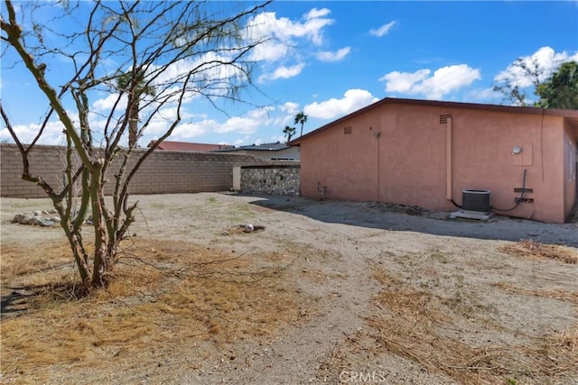 view of home's exterior with central air condition unit, fence, and stucco siding