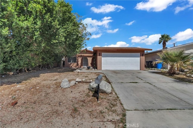 ranch-style house with concrete driveway, an attached garage, and stucco siding