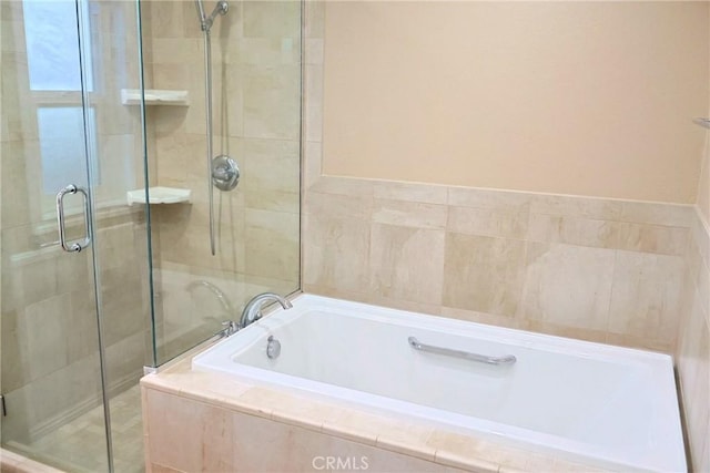 bathroom featuring a stall shower and a garden tub