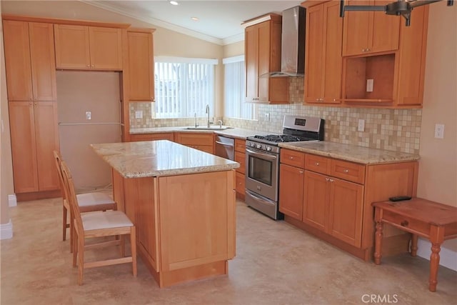 kitchen featuring stainless steel appliances, a kitchen island, a sink, ornamental molding, and wall chimney range hood