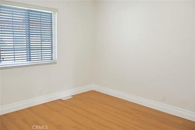 empty room with light wood-style flooring and baseboards