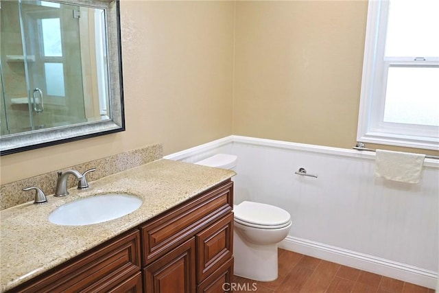 full bath with toilet, an enclosed shower, wood finished floors, and vanity