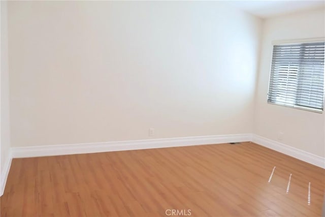 unfurnished room featuring light wood-style flooring and baseboards