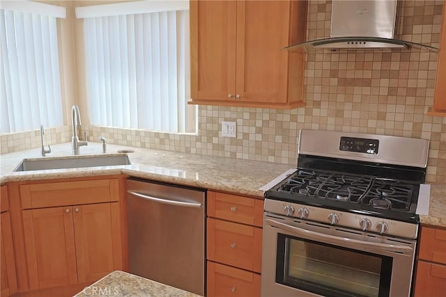 kitchen with light stone counters, tasteful backsplash, appliances with stainless steel finishes, a sink, and exhaust hood