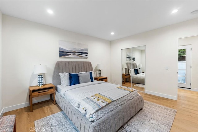 bedroom featuring light wood finished floors, a closet, recessed lighting, and baseboards