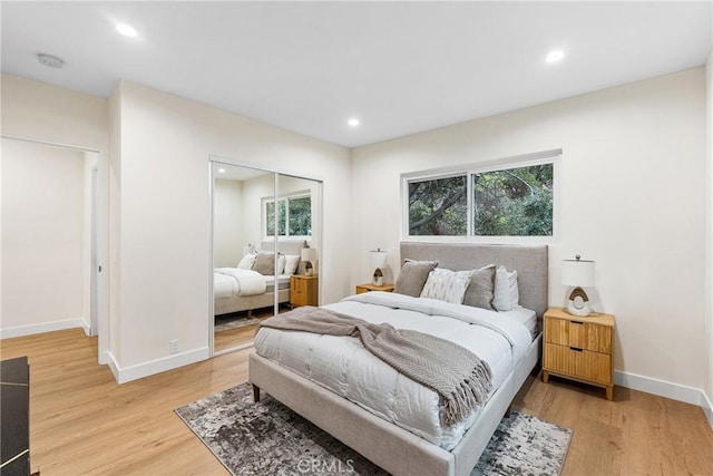 bedroom with light wood-style floors, baseboards, a closet, and recessed lighting