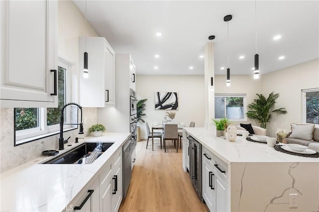 kitchen with appliances with stainless steel finishes, a sink, and white cabinetry