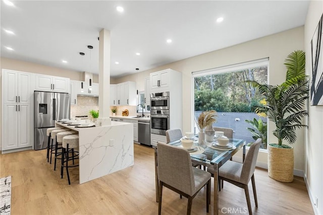 dining space with light wood-style floors and recessed lighting