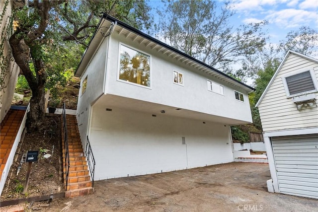 exterior space featuring stairway and stucco siding