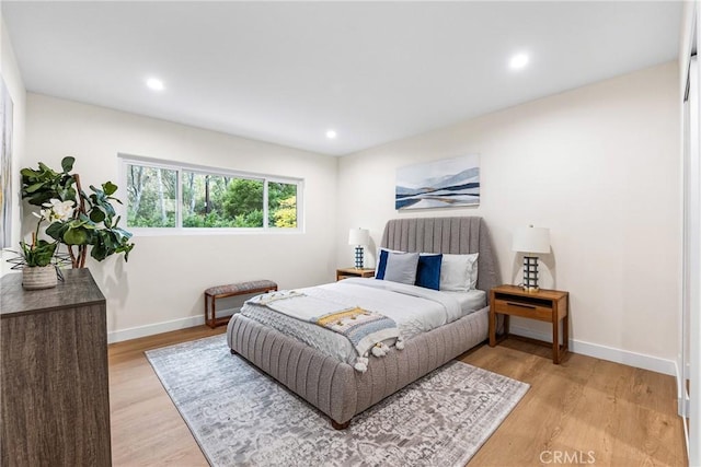 bedroom featuring light wood finished floors, recessed lighting, and baseboards