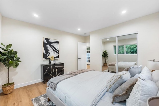 bedroom featuring light wood-style floors, recessed lighting, a closet, and baseboards