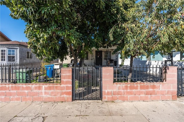 view of front of home with covered porch, a fenced front yard, and a gate