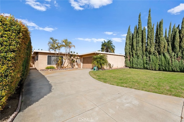 mid-century modern home with a front yard, driveway, and stucco siding