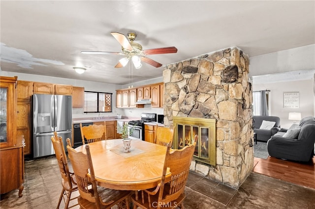 dining room with a fireplace and a ceiling fan