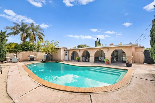 view of pool featuring a patio, area for grilling, fence, and a fenced in pool