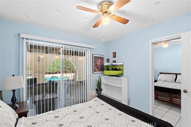 tiled bedroom featuring access to outside, ceiling fan, and a textured ceiling