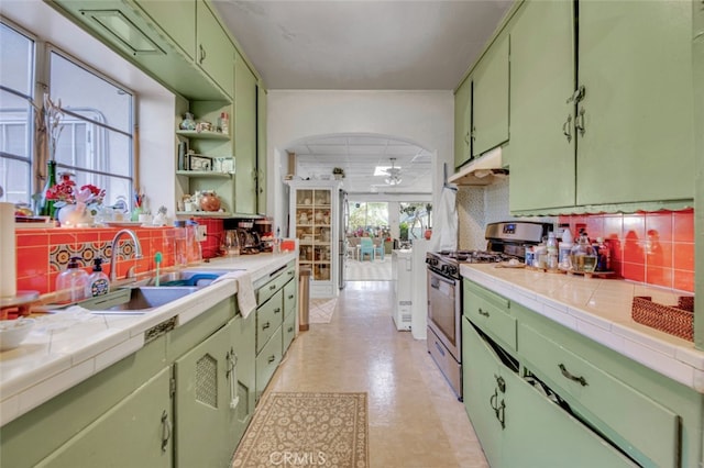 kitchen featuring stainless steel gas stove, green cabinets, and under cabinet range hood