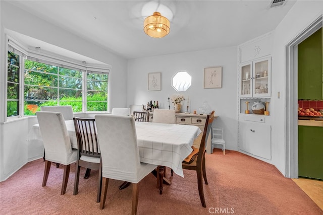 dining area with light carpet and visible vents