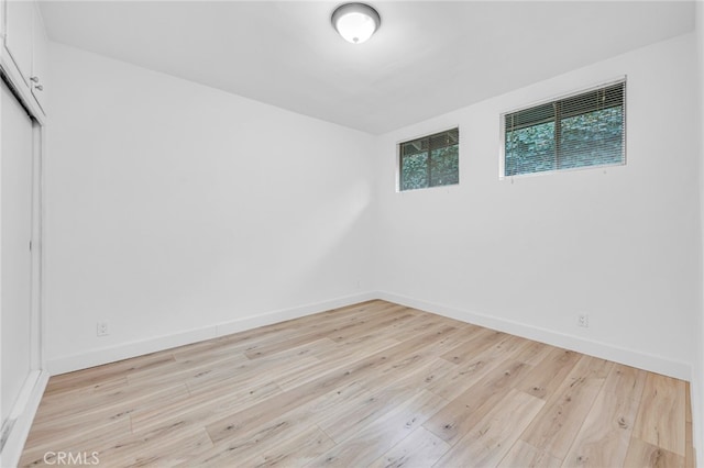 spare room featuring visible vents, baseboards, and wood finished floors