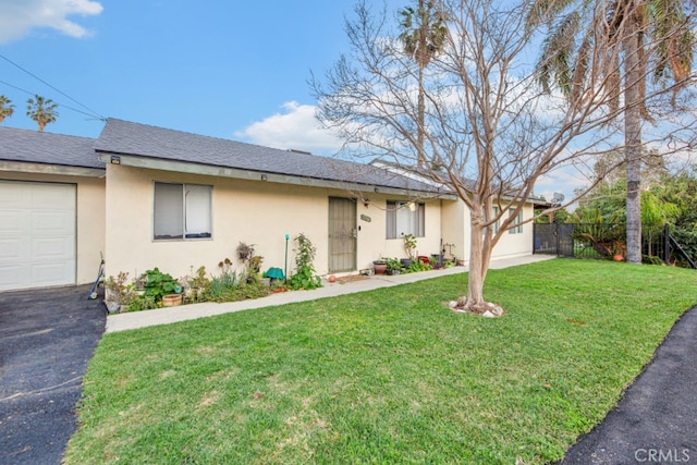 ranch-style house featuring stucco siding, a shingled roof, fence, a garage, and a front lawn