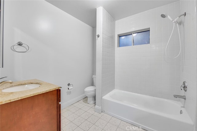 bathroom with bathtub / shower combination, toilet, vanity, baseboards, and tile patterned floors