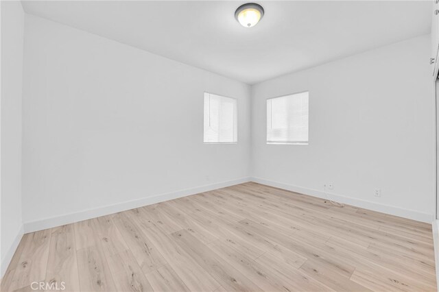 spare room with light wood-style flooring and baseboards