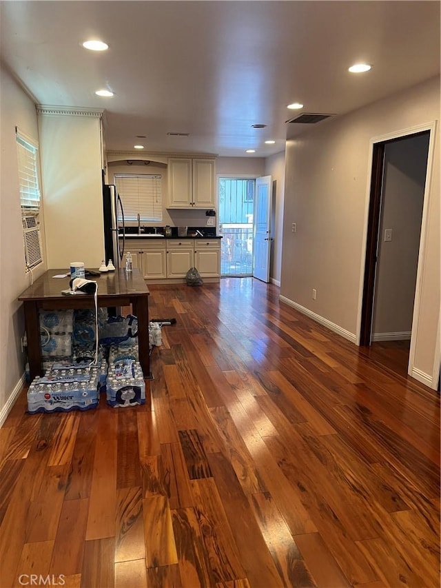 kitchen featuring dark wood finished floors, dark countertops, a sink, and freestanding refrigerator