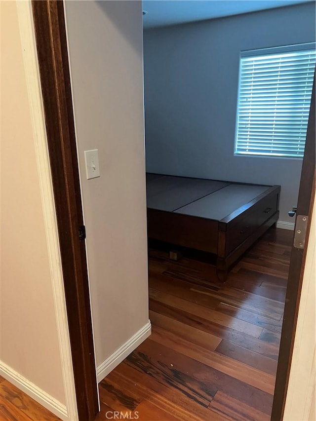 unfurnished bedroom with wood finished floors and baseboards