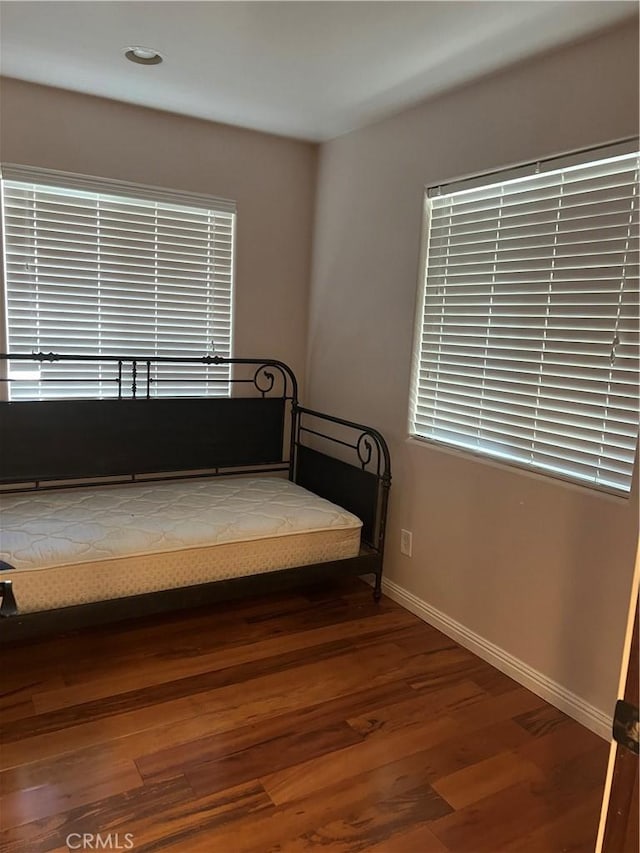 unfurnished bedroom with baseboards and wood finished floors