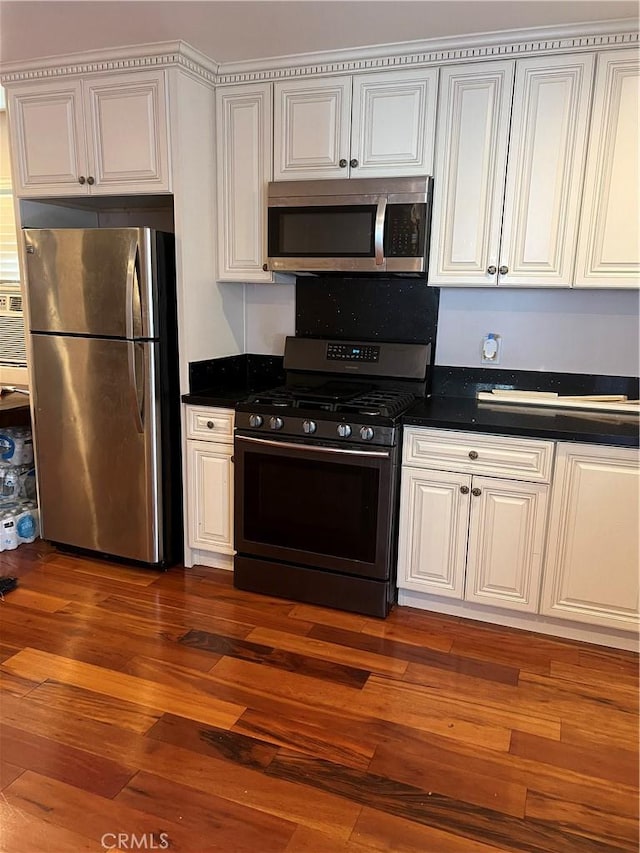 kitchen with dark countertops, appliances with stainless steel finishes, and dark wood-style flooring