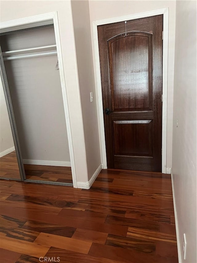 hallway with baseboards and wood finished floors