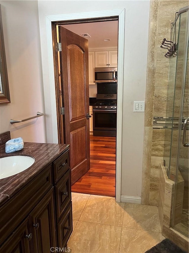 full bath with a stall shower, visible vents, vanity, and tile patterned floors