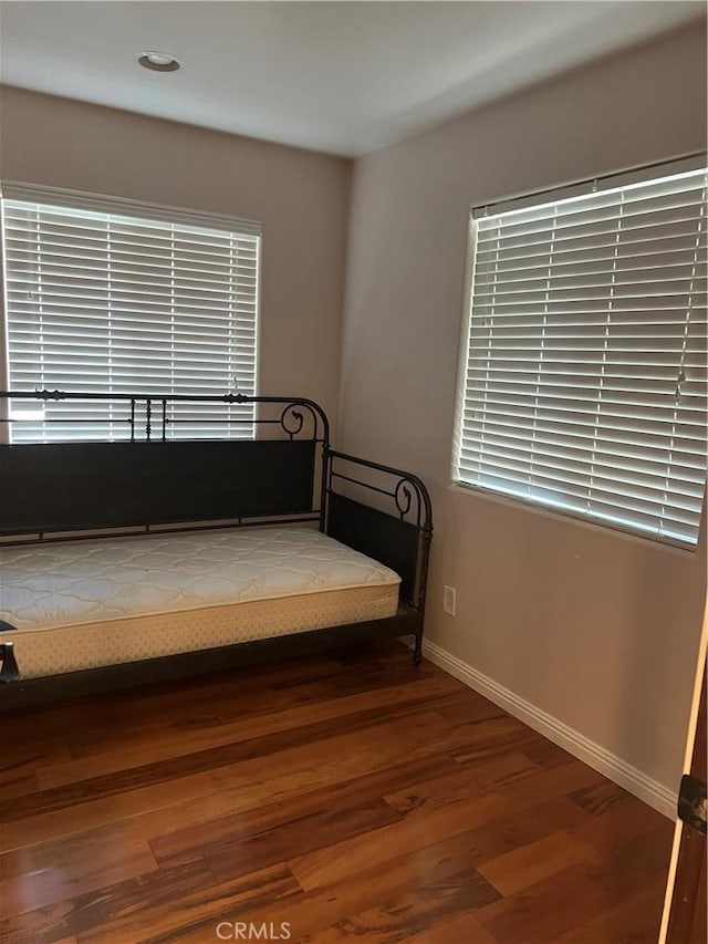 unfurnished bedroom with baseboards and wood finished floors