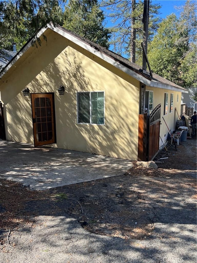 back of property featuring a patio area and stucco siding