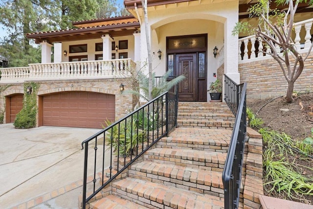 entrance to property featuring driveway, brick siding, covered porch, and stucco siding