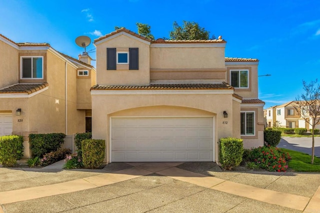 view of front of home featuring a garage, concrete driveway, a tile roof, and stucco siding