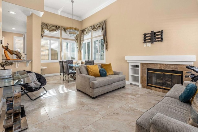 living room with baseboards, ornamental molding, and a tiled fireplace