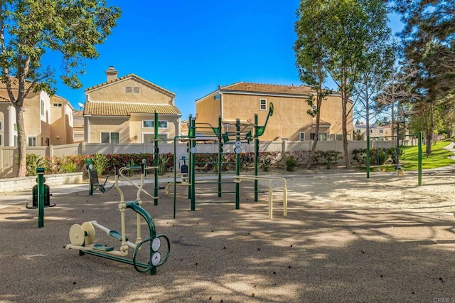 community play area featuring fence and a residential view