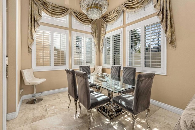 dining area featuring baseboards and a notable chandelier