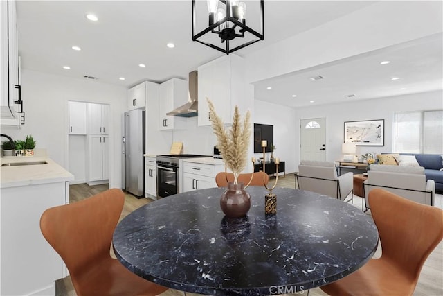 dining room featuring light wood-style floors, recessed lighting, and visible vents