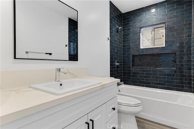 bathroom featuring washtub / shower combination, vanity, toilet, and wood finished floors