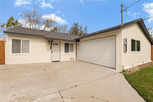 single story home with driveway, fence, an attached garage, and stucco siding