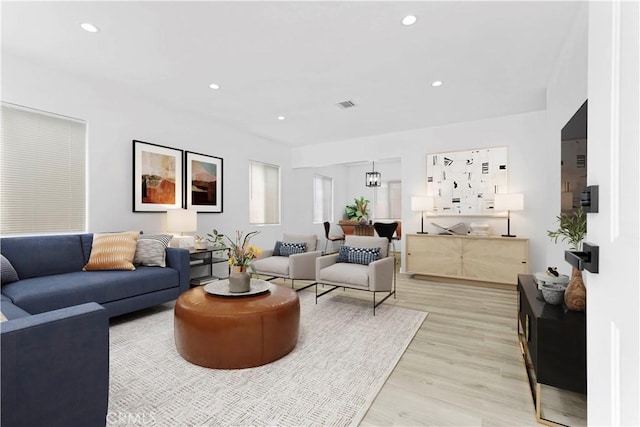 living room featuring light wood-style floors, visible vents, and recessed lighting