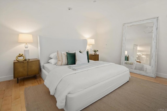 bedroom featuring light wood-type flooring and baseboards