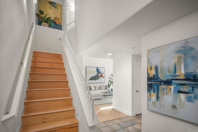 staircase with baseboards and tile patterned floors